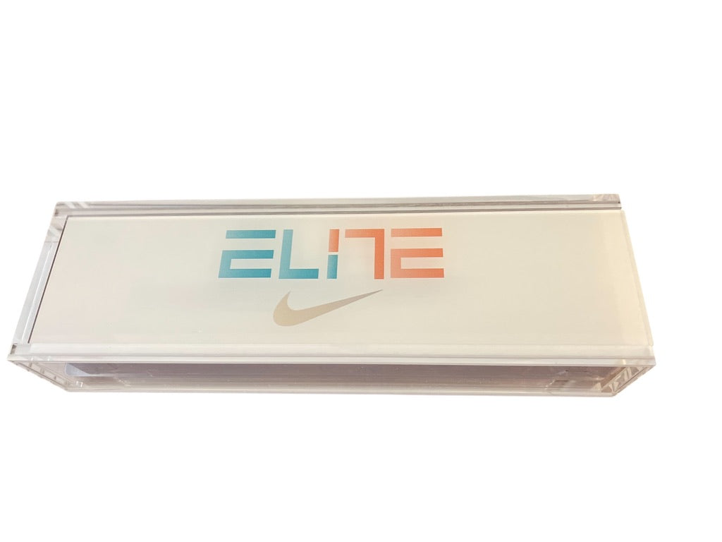 A Nike Elite acrylic display case, featuring a clear rectangular plastic shell with a frosted white back panel printed with the word 'ELITE' in blue and orange and a gold swoosh.