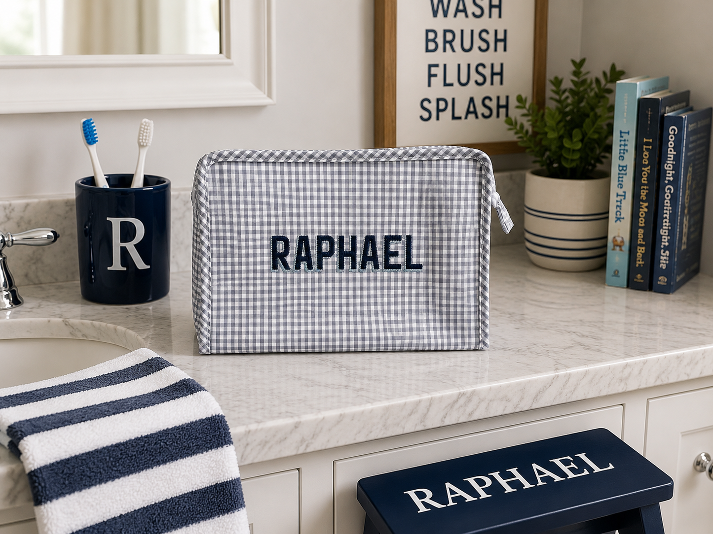 Personalized toiletry bag and step stool on a bathroom counter with 'Raphael' branding.